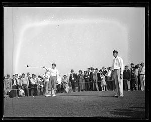 Spectators watching golfers play golf