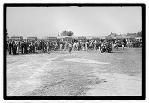 A crowd of people gathered by buses