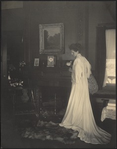 Mary "Mollie" Stevens Dodge (Mrs. Edward Sherman Dodge) in white dress standing in front of fireplace