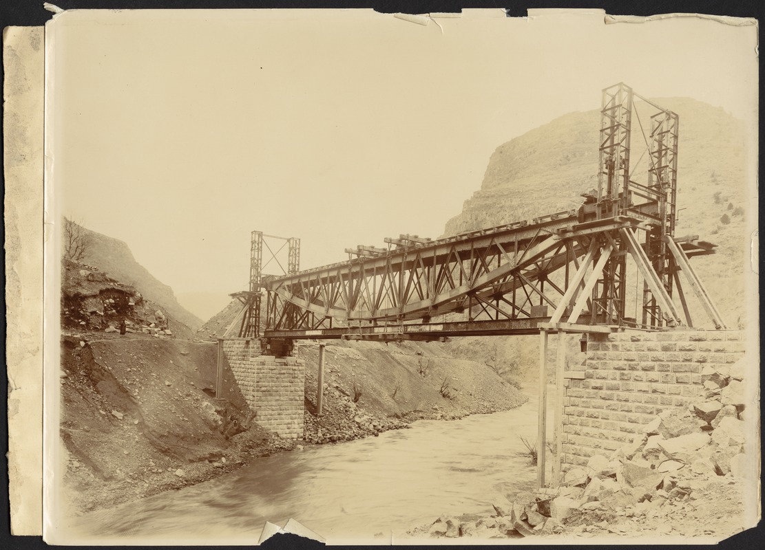 Steel bridge over river with stone anchorage