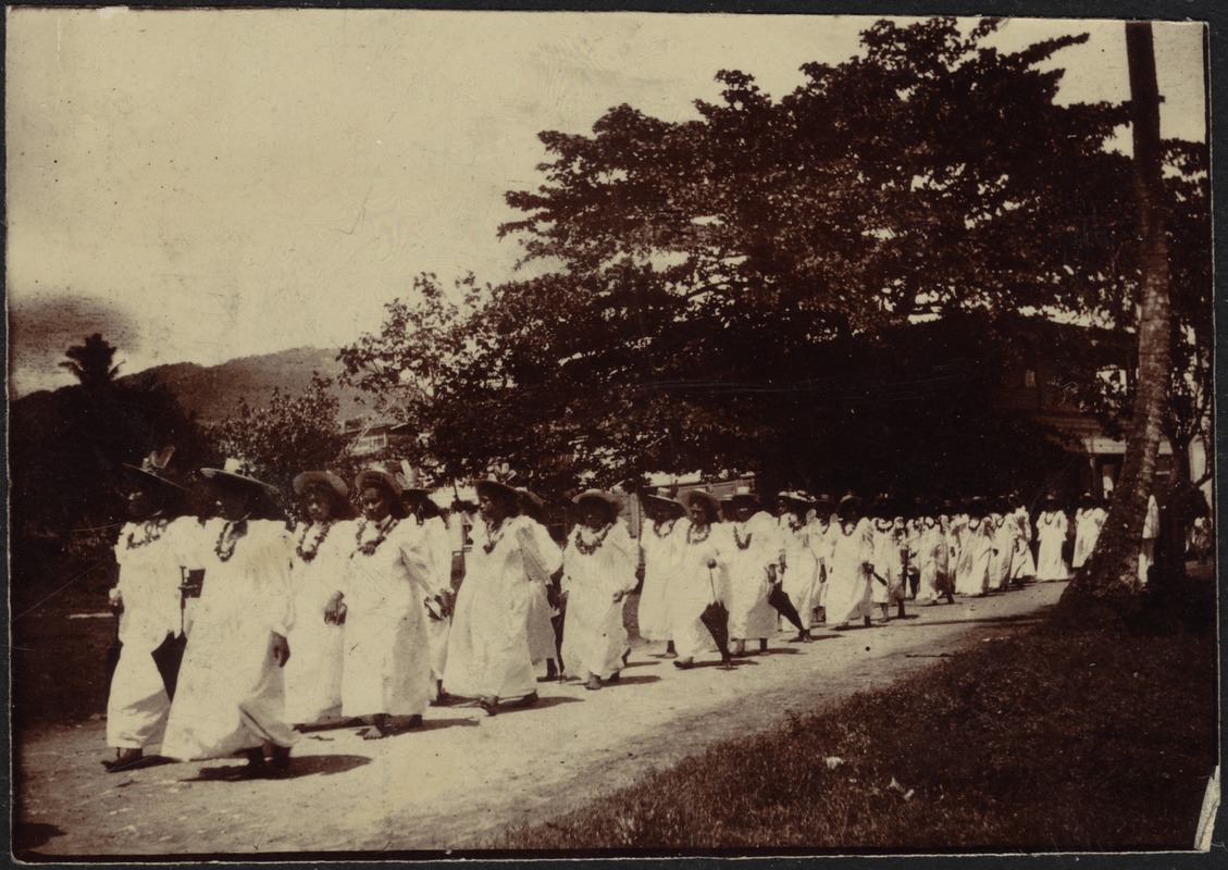 Large group of women in white dresses walking along a road - Digital ...