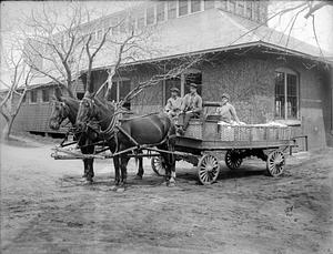 View of three men on a delivery wagon