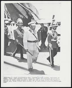 Visit in Ethiopia--Gen. Ibrahim Abboud, center, president of Sudan, walks with Emperor Haile Selassie, right, of the Ethiopia, on Abboud's arrival at Addis Ababa airport a week ago for a state visit. The Emperor's eldest son, Crown Prince Asfa Wossen, is at left.