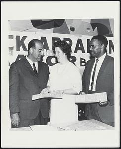 Campaign workers look to Nicholas Abraham, millionaire businessman and realtor, who is seeking nomination for Mayor of Boston. More than 100 workers attend the weekly committee meetings at Campaign Headquarters in Roslindale. Shown with Abraham are Mrs. Eleanor Cawley of Readville and James McIntyre of Roxbury. Abraham advocates a direct communication line between community betterment committees and city hall.