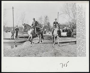 Levee Patrol -- Earl Gile (left) and LaVergne Aumock patrol a dike in a low section of Onalaska, suburb, where work is in progress building barriers to stem flood waters of the Mississippi River today. The men are members of auxiliary police who patrol dikes on a 24-hour basis during the crisis.
