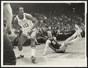Boston Celtics guard Jo Jo White handles the ball while Cincinnati Royals player Tom Van Arsdale falls to floor