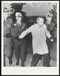 Fort Devens. MPs, escort unidentified person, who tried to rip down, anti Johnson signs man claimed to be ex-G. I.