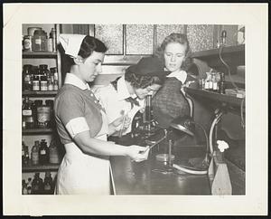 Student nurse Phyllis Little makes laboratory test for Jeanette Trojak (center) and Dorothy McManus, of Roxbury Memorial Girls' High, at Faulkner Hospital.