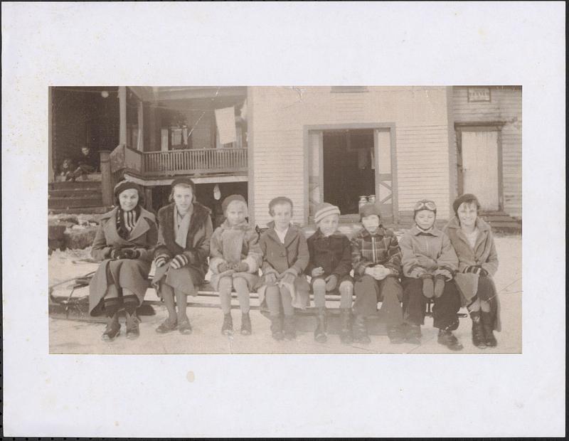 Neighborhood children sitting on a sled in front of the Stefanic home