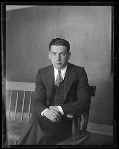 Unidentified seated man holding a cigarette