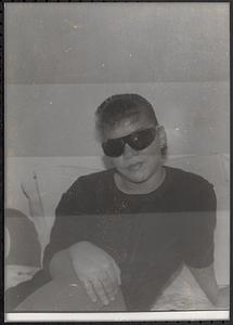 Young woman on a bed wearing sunglasses