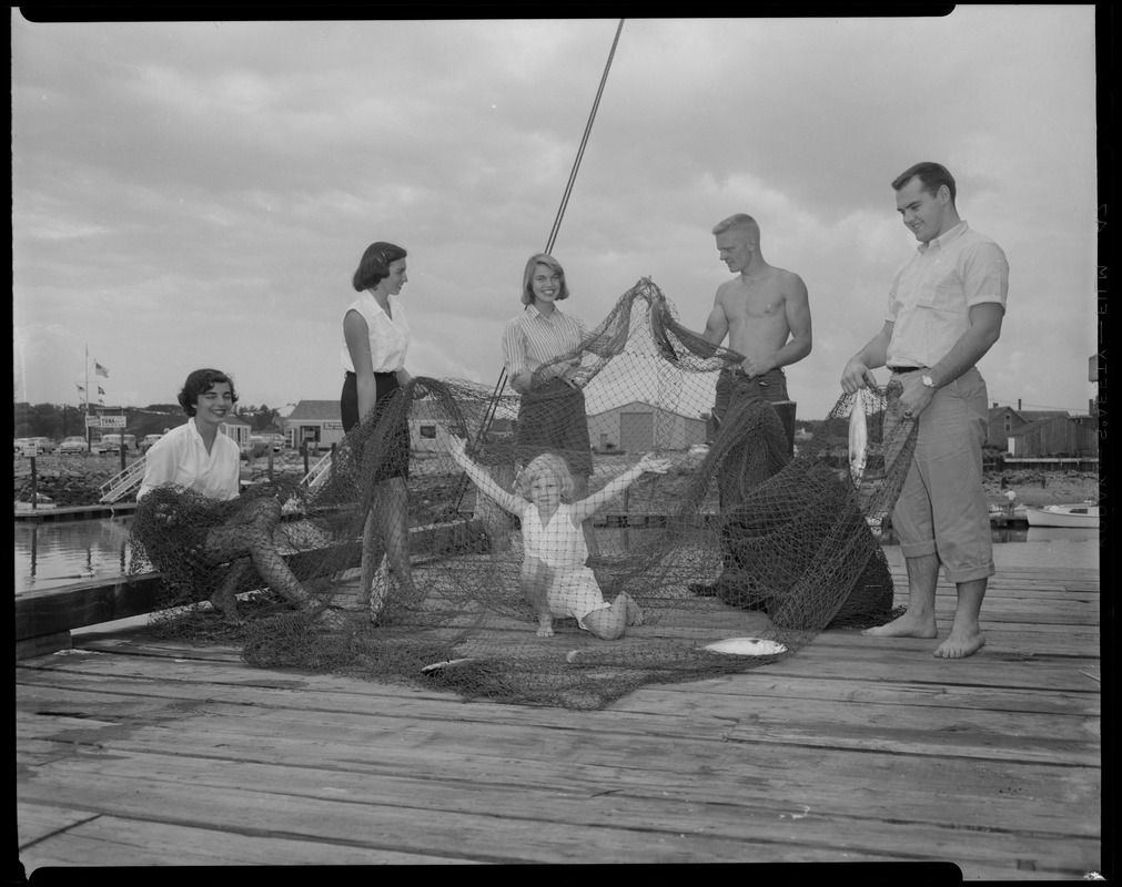 Group with fishnet, pulling dory in water