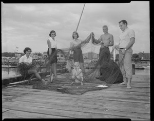 Group with fishnet, pulling dory in water