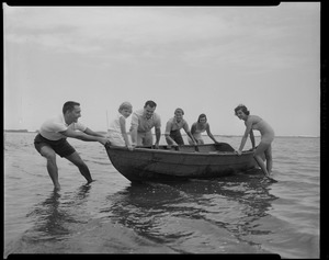 Group with fishnet, pulling dory in water