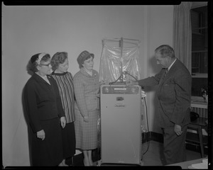 Man and three women rotarians with MechanAir machine that the women of the Harwich Dennis Rotary donated (to Cape Cod hospital?)