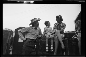 Unidentified man in cowboy hat with woman and child
