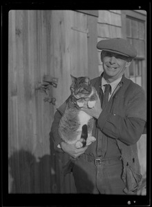 Unidentified smiling man with cat