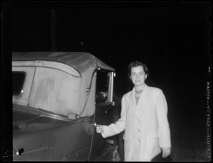 Unidentified woman in coat beside car