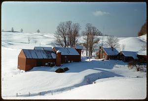Barn and house on snow-covered hill