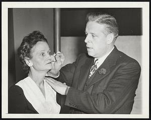 School For Hypnotists. New York- Without batting an eye, Kay Dugan, student of hypnology, watches while teacher Clark Bellows holds a match close to her face. Under the spell of hypnosis, a subject is supposed to feel neither fear nor pain.