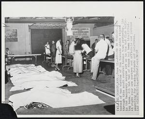 Killed in Tornado-The bodies of ten victims of the tornado which ripped through this south central Kansas town yesterday, lie in the temporary morgue set up in the 4-H Club building here. All but two of these had been identified. At right rear are workers and officials and persons searching for missing friends and relatives.