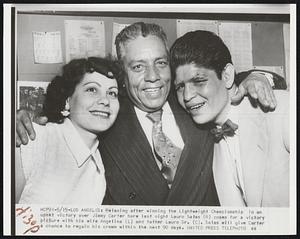 Relaxing after winning the Lichtweight Championship in an upset victory over Jimmy Carter here last night Lauro Salas (R) poses for a victory picture with his wife Angelina (L) and father Lauro Sr. (C). Salas will give Carter a chance to regain his crown within the next 90 days.