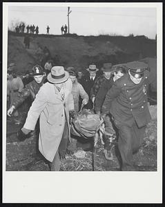 Carrying body of steam shovel operator to police ambulance. The cliff that collapsed in background