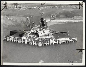 Storm-torn Pemberton pier as it appeared from the air today to Herbert Stier, Traveler staff photographer. The pier itself was battered and strewn with wreckage.