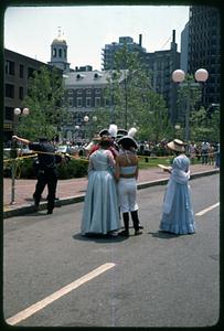 A group of people in colonial costume near Faneuil Hall