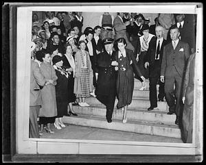 Unidentified woman being escorted down stairs by a policeman