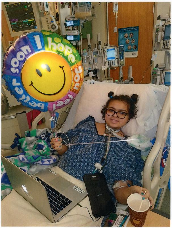 Abigail Garcia smiling as she gets a 'get well soon' balloon after her tracheotomy
