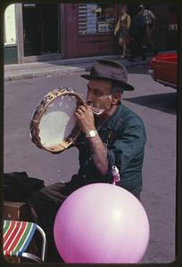 Man playing tambourine and harmonica