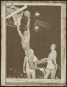 Flying Bill Russel from Boston scores two points as Connie Dierking (24) of Cincinnati could only watch. Action took place here in 2nd quarter.