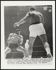 Cassius Clay, white trunks, the 210 pound, 6 foot 3 champion, towers over challenger Floyd Patterson as the two fighters traded punches in the 5th round of their 15-round title bout, 1 1/22, in the Las Vegas Convention Center.