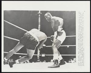 Going Down-- Floyd Patterson, victim of a left hook, heads for canvas tonight in heavyweight title fight in Chicago. Sonny Liston, challenger, has just belted Patterson in first round. Patterson stayed down for the count and was kayoed