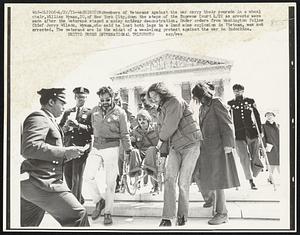 Washington:Members of Veterans Against the War carry their comrade in a wheel chair,William Wyman,20,of New York City,down the steps of the Supreme Court 4/22 as arrests were made after the veterans staged a noisy antiwar demonstration. Under orders from Washington Police Chief Jerry Wilson, Wyman,who said he lost both legs in a land mine explosion in Vietnam, was not arrested. The veterans are in the midst of a week-long protest against the war in Indochina.