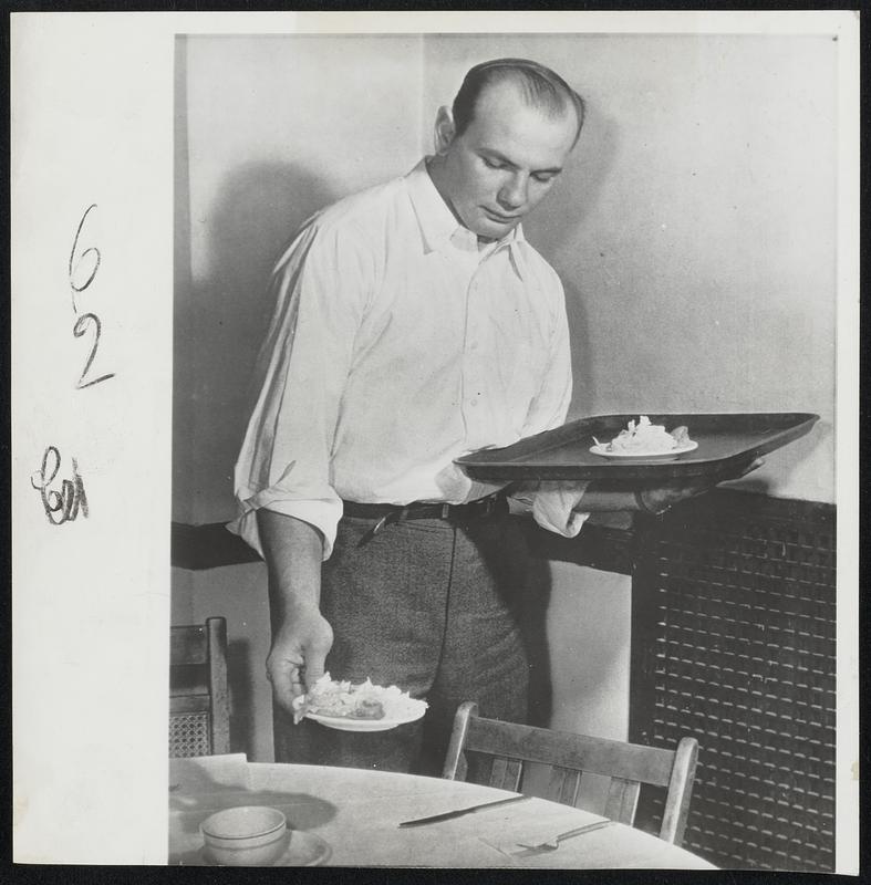 All-America Star at Work-John "Bull" Schweder, All-America guard on the University of Pennsylvania football team, waits on the basketball team's training table. Schweder laughs at the theory that top athletes are financially set because the college or alumni take care of them. He said he "never got a nickel" and is going through college on the GI Bill of Rights.