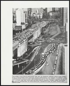 Bridging the Gap in Transit Strike -- This view taken from a helicopter this morning shows pedestrians and bumper to bumper auto traffic, left, moving down the Manhattan end of the Brooklyn Bridge as people get to work any way they can in New York's transit tieup. Domed building in center background is City Hall.