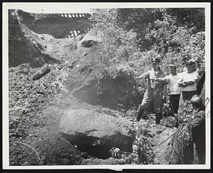 Where Two Were Trapped in Landslide - State Trooper Forman Spafford and unidentified workmen examine spot in Buckland, Mass., where Winsek Sabin, 68, lost life in heavy landslide. Search continued for second victim, Harold Clark, 40. They were buried while working.