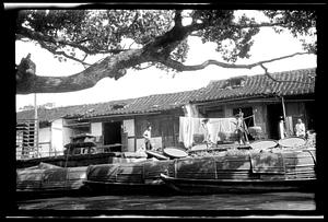 Sampans parked at water's edge, buildings in the background