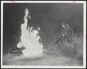 Fighting Medford Gas Leak Fire-Firemen cautiously approach flames leaping from a natural gas leak in the marsh lands off Mystic Valley Parkway, Medford, early today. Later in the morning emergency crews found the break and slipped a metal sleeve over the leak.