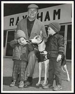 Raynham Arrivals - Owner-trainer Frank Conroy poses at left in front of Raynham Dog Track with Dennis (3) and Timmy (4) Carney and greyhound Roiterri, Imp.