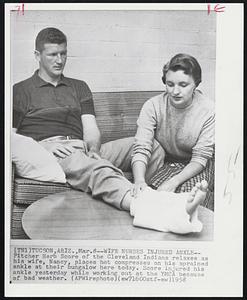 Wife Nurses Injured Ankle-- Pitcher Herb Score of the Cleveland Indians relaxes as his wife, Nancy, places hot compresses on his sprained ankle at their bungalow here today. Score injured his ankle yesterday while working out at the YMCA because of bad weather.