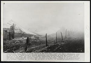 Storm Damage in the Dust--Emil (left) and Albert DeBrabander stand in the shelter of their father's wrecked greenhouse here yesterday as they watch clouds of dust blow out of the west. The black dust clouds, reminiscent of the storms of the 1930's, swirled off Kansas fields and were whipped across the state on high winds. Damage to the greenhouse and it's content, flattened by the wind, was estimated at $1,500.