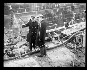A police officer speaking to an unidentified man by some debris