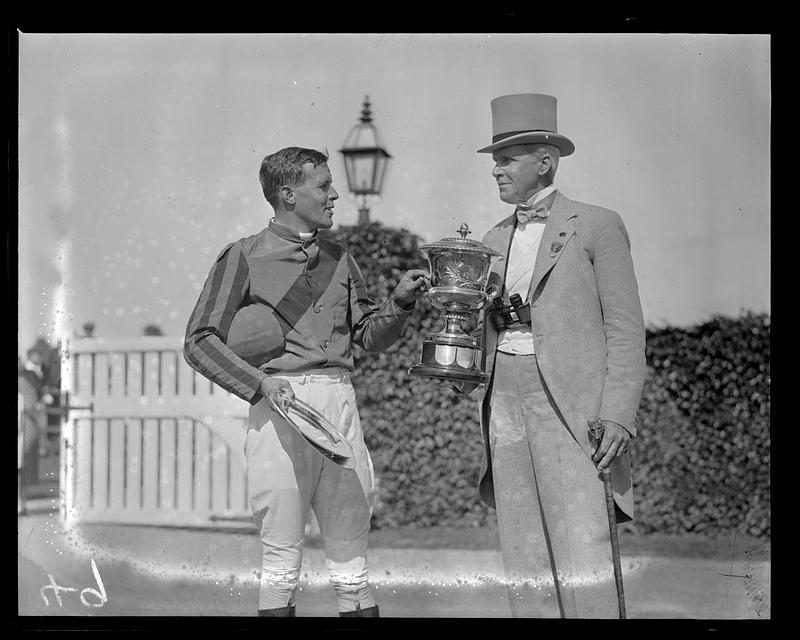 A jockey being presented a trophy