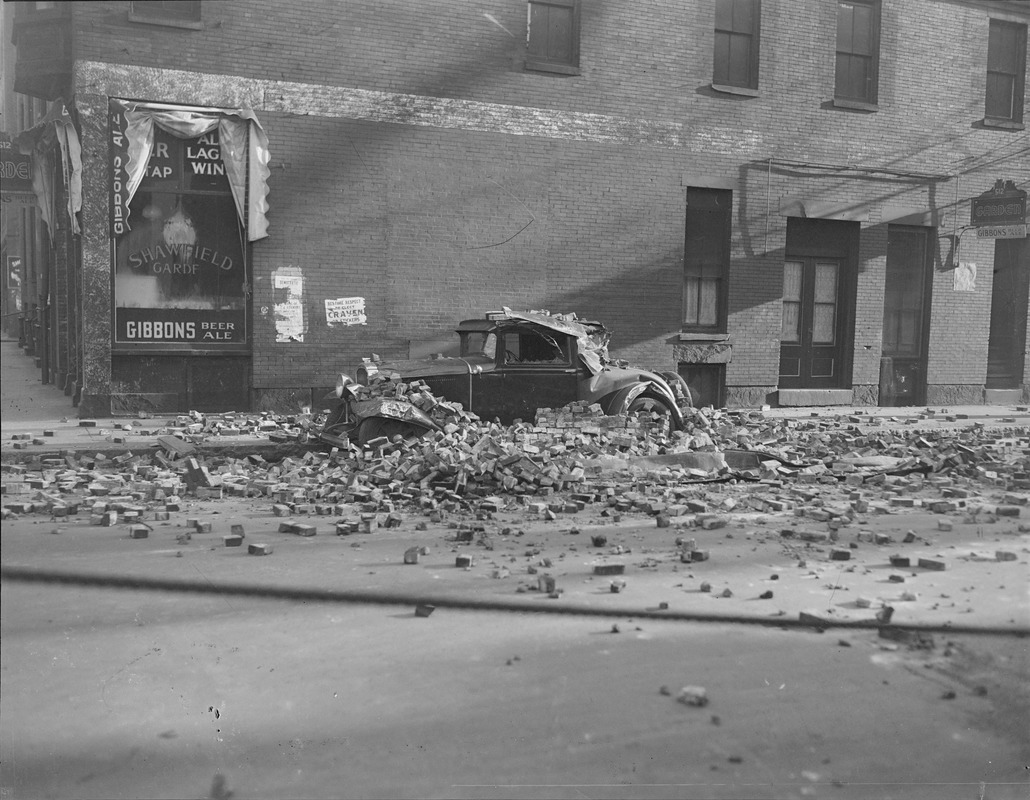 Building crumbles on parked auto