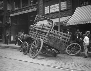 Horse-drawn cart loses wheel, Washington Street near Adams Sq.