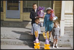 Children standing on steps with Easter baskets and decorations