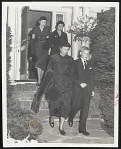 Mourning Family – Mrs. Maurice J. Tobin and her son, Maurice Jr., walk down the steps of their Jamaica Plain home today. Behind them are daughters Helen (left) and Carol.